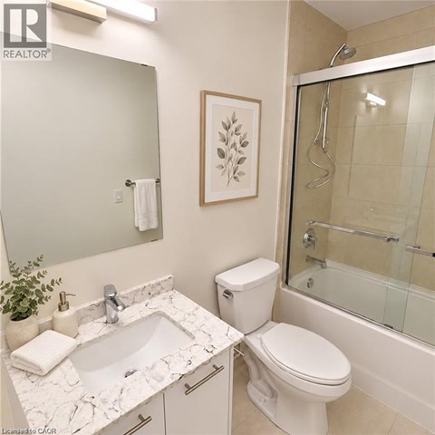 A white bathroom with a marble counter top and a toilet.