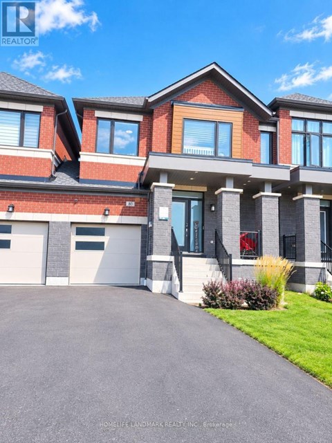 A large, modern house with a red brick facade and a grey garage door.