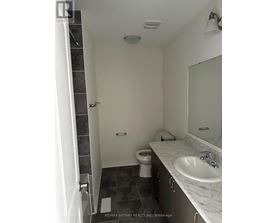A bathroom with a toilet, sink, and mirror.