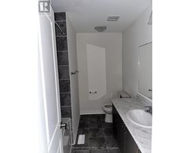 A bathroom with a toilet, sink, and shower.
