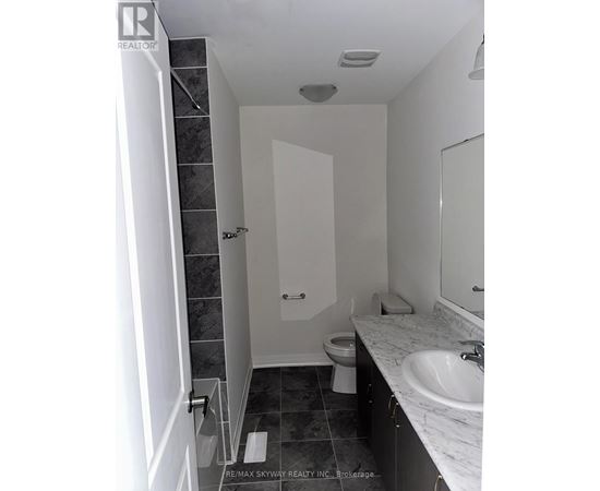 A bathroom with a toilet, sink, and shower.