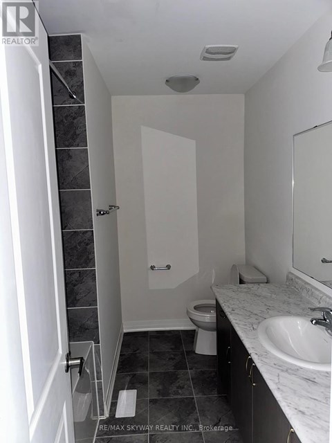 A bathroom with a toilet, sink, and shower.