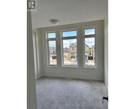A room with three windows showing an outdoor view of a residential area.