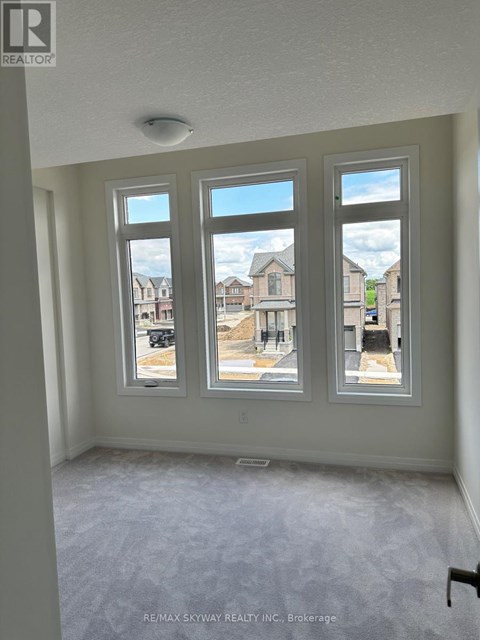 A room with three windows showing an outdoor view of a residential area.