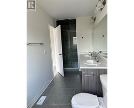 A bathroom with a toilet, sink, and mirror.