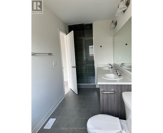 A bathroom with a toilet, sink, and mirror.