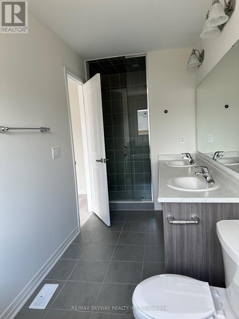 A bathroom with a toilet, sink, and mirror.