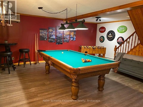 A pool table in a room with a staircase.