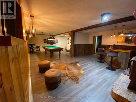 A room with a pool table and a cowhide rug.