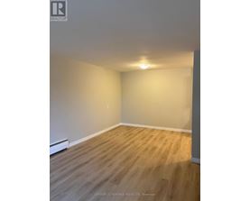 A room with wooden flooring and white walls.