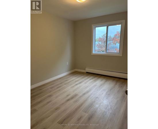 A room with a window showing trees outside.