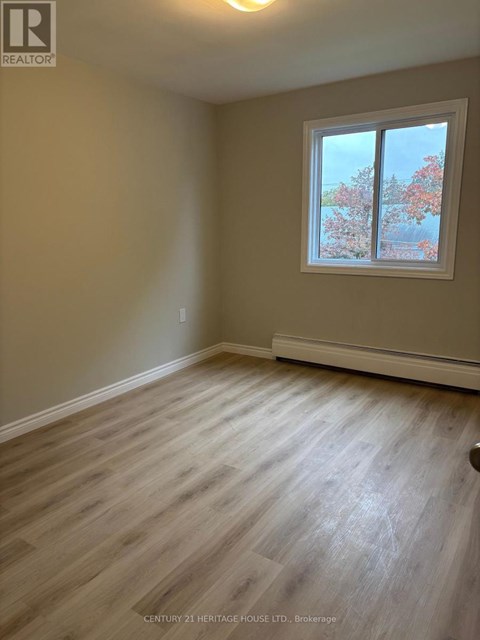 A room with a window showing trees outside.