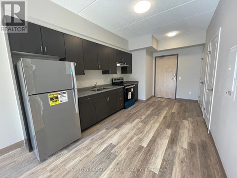 A kitchen with a refrigerator, cabinets, and a countertop is shown.