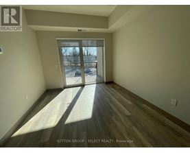 A room with wooden flooring and a sliding glass door leading to a snowy landscape.