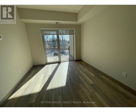 A room with wooden flooring and a sliding glass door leading to a snowy landscape.