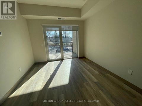 A room with wooden flooring and a sliding glass door leading to a snowy landscape.