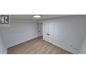 A white room with a wooden floor and a door.
