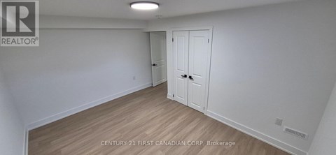 A white room with a wooden floor and a door.