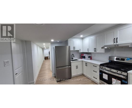 A kitchen with white cabinets and a stainless steel refrigerator.