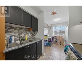 A kitchen with black cabinets and a stone backsplash is for sale.
