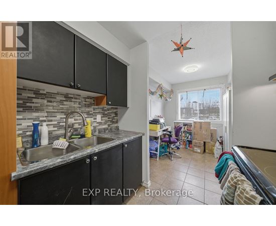 A kitchen with black cabinets and a stone backsplash is for sale.