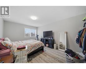 A bedroom with a bed, a TV, a wardrobe and a window.
