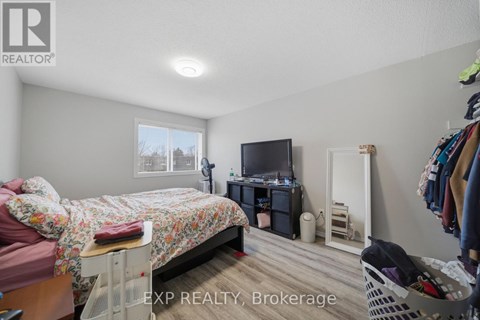 A bedroom with a bed, a TV, a wardrobe and a window.