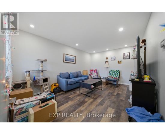 A living room with a couch, chair, and a table with boxes on it.