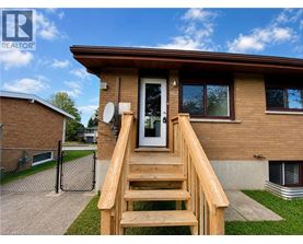 A house with a brown roof and a wooden staircase leading to the front door.