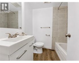 A white bathroom with a toilet, sink, and bathtub.
