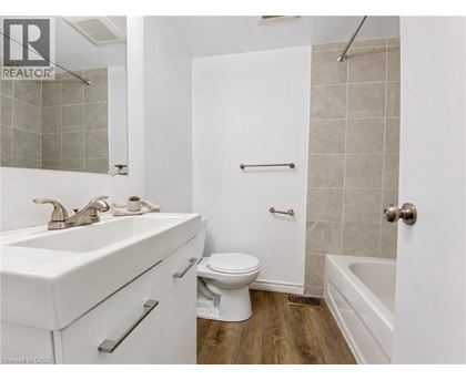 A white bathroom with a toilet, sink, and bathtub.