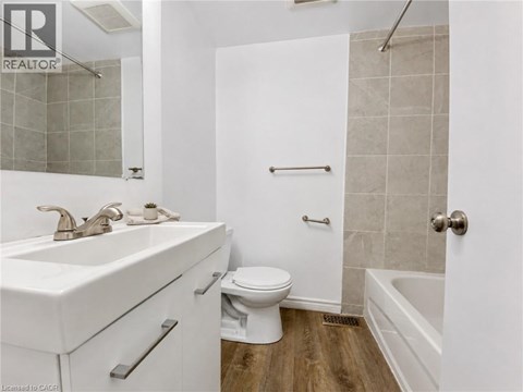 A white bathroom with a toilet, sink, and bathtub.
