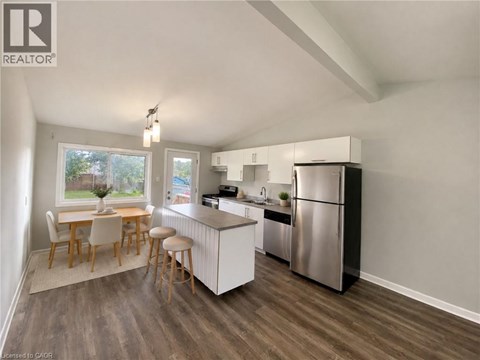 A kitchen with a refrigerator, stove, and dining table.