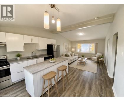 A well-lit kitchen with white cabinets and a wooden island.