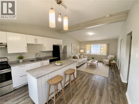 A well-lit kitchen with white cabinets and a wooden island.