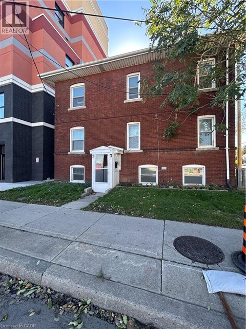 A red brick building with a white door and windows.