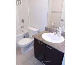 A white toilet sits next to a sink in a bathroom.