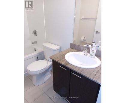 A white toilet sits next to a sink in a bathroom.