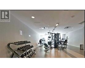A gym with a variety of equipment including dumbbells, weight machines, and a bench press.