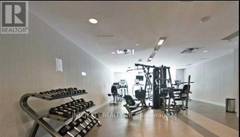 A gym with a variety of equipment including dumbbells, weight machines, and a bench press.
