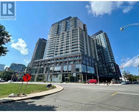 A modern glass building with a red stop sign in front of it.