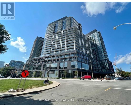 A modern glass building with a red stop sign in front of it.