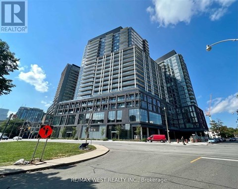 A modern glass building with a red stop sign in front of it.