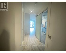 A hallway with a glass door leading to another room.