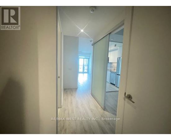 A hallway with a glass door leading to another room.