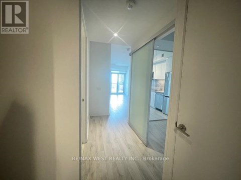 A hallway with a glass door leading to another room.