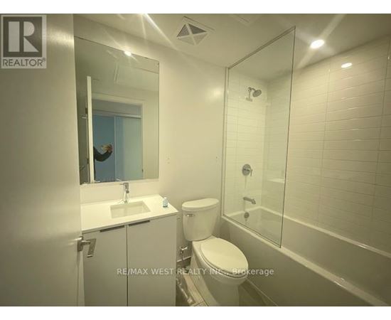 A bathroom with a toilet, sink, and shower.