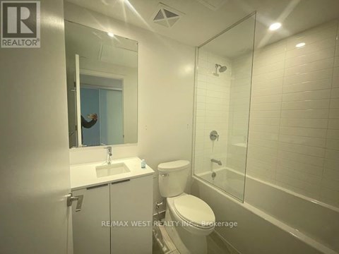 A bathroom with a toilet, sink, and shower.
