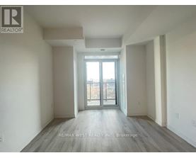 A spacious room with a sliding glass door leading to a balcony.