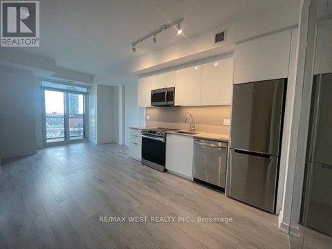 A spacious kitchen with white cabinets and stainless steel appliances.